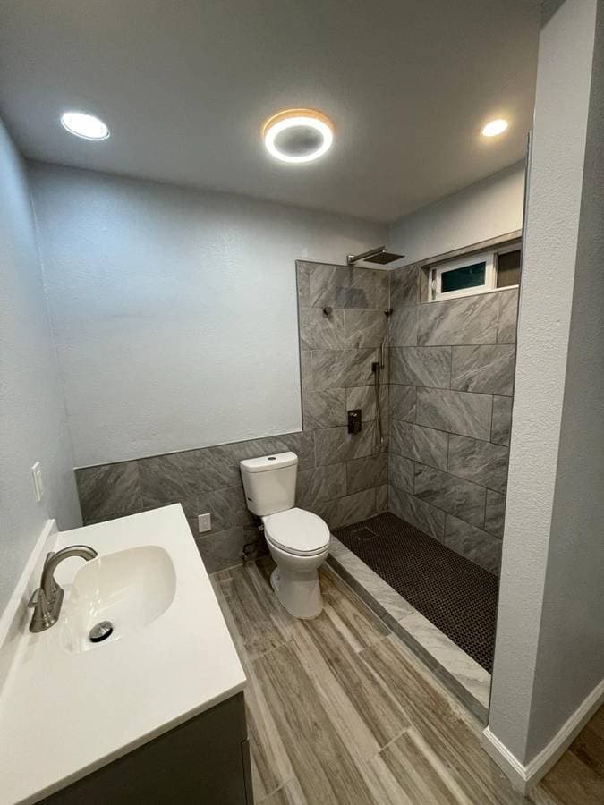 picture of a newly remodeled bathroom with new floors and shower tiling