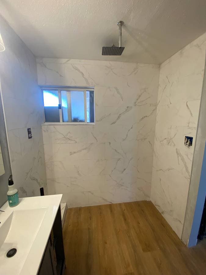 picture of a remodeled bathroom with granite walls and flooring